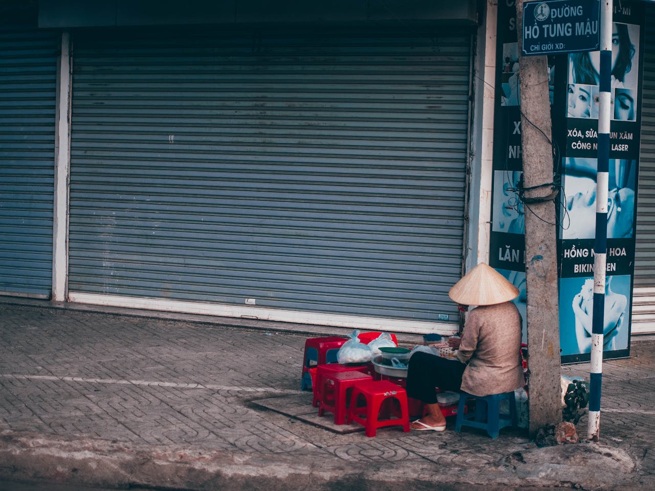 A traditional street vendor setup in Buon Ma Thuot, Vietnam against closed shop shutters.
